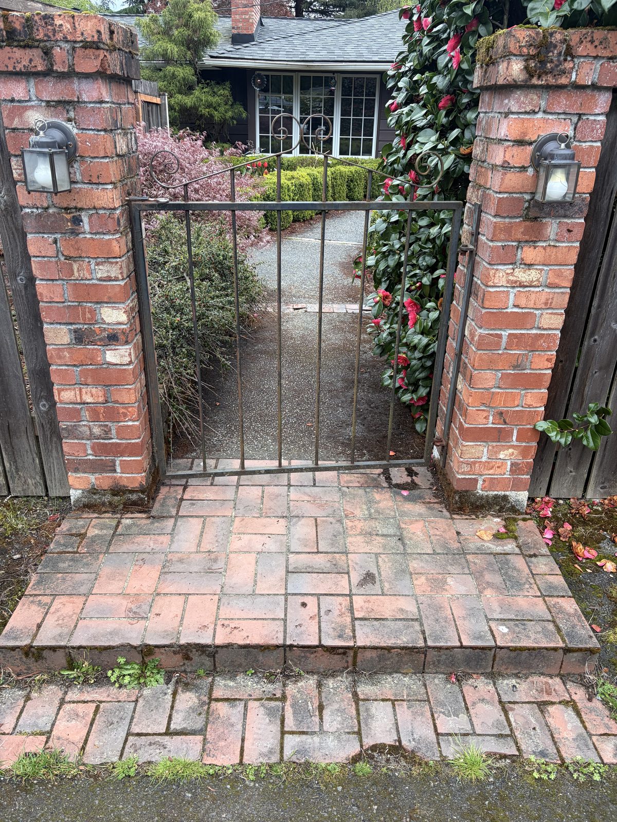Brick walkway and entry gate before pressure washing — dirty, dull, and weathered